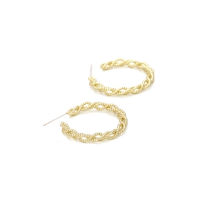 Detail of gold beaded twisted rope earrings with intricate metallic texture and design