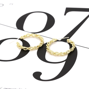 Modern twisted gold hoop earrings with woven texture and minimalist chunky chain design
