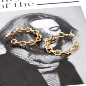 Trendy gold Cuban chain link C-shaped hoop earrings with polished finish on magazine