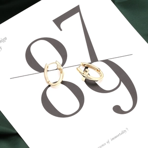 Minimalist gold-plated cross hoop earrings for women presented on a minimalist card