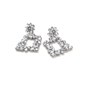 Detailed view of silver-tone flower earrings with hollow geometric squares and crystals