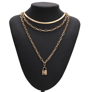 Three-layer gold layered necklace set with snake chain and padlock pendant on display