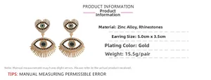 Detail of gold heart earrings with evil eye design and encrusted rhinestones