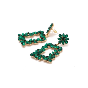 Close-up of emerald green crystal floral earrings with vintage hollow gold alloy base
