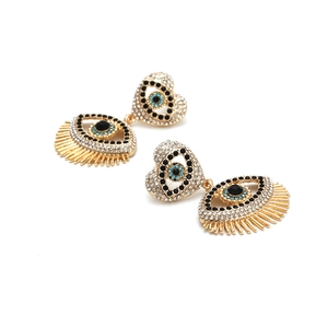 Golden heart earrings with evil eye pendants and sparkling crystal accents on white background