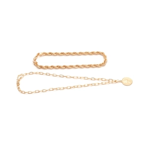 Detail of layered gold rope chain and link necklace with coin emblem pendant