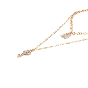 Collier double couche doré avec pendentifs clé et cadenas sertis de cristaux étincelants