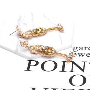 Boucles d'oreilles verres à vin dorées avec perles et strass sur plateau en marbre