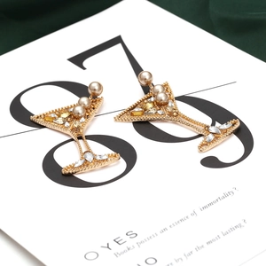 Détail macro de boucles d'oreilles en verre à vin avec perles et strass