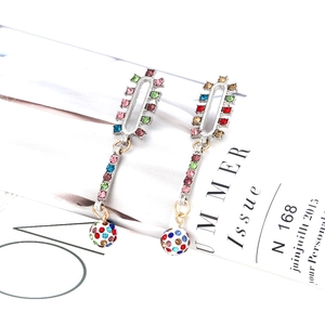 Détail de boucles d'oreilles bohèmes longues avec strass colorés sur un magazine mode