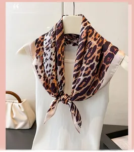 Detail of silk-like leopard print scarf featuring soft pink edges and smooth texture