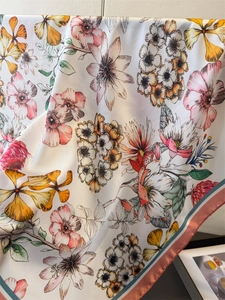Close-up of printed silk scarf showing vibrant floral patterns and smooth satin texture