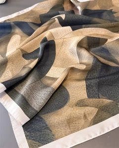 Detailansicht eines Seidenschals mit abstraktem Druck und feiner Rollsaum-Kante