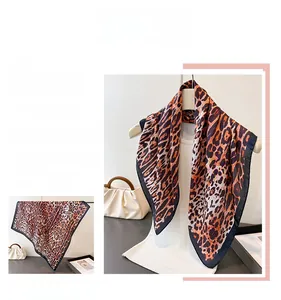 Detail view of leopard print silk scarf showing smooth texture and edge stitching