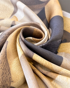 Makro-Detail des Seidenschals mit geometrischem Druck und satinierter Textur