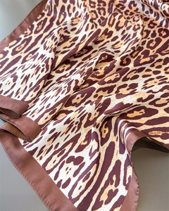 Close-up of leopard print silk scarf showing fabric texture and brown solid border
