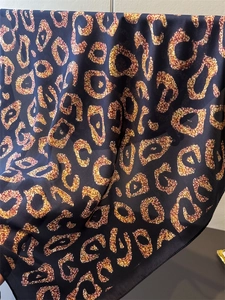 Detailed close-up of leopard print satin scarf showing fine hemmed edges and texture