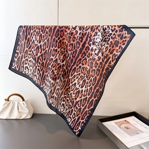 Detail of leopard print silk scarf with fine black edges draped on a luxury display