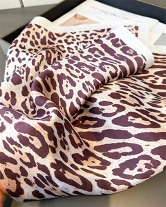 Detail of leopard print silk scarf with satin luster and elegant white stitched edges