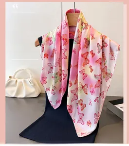 Detail of silk-like scarf with vibrant butterfly prints draped over a fashion mannequin