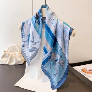 Carré de soie bleue avec imprimé équestre et motifs de chevaux drapé sur un mannequin