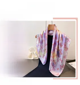 Detail shot of butterfly print on gradient silk scarf featuring purple and pink hues