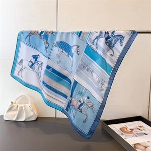 Détail d'un foulard en soie avec imprimé équestre et ourlet roulé sur une tige en métal