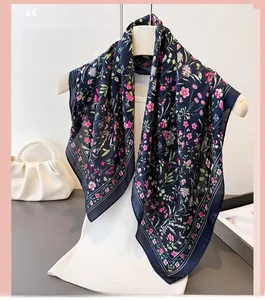 Détails de la texture soyeuse à motif floral rétro et bordure bleu foncé du foulard