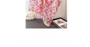 Detail of pink silk scarf featuring colorful butterfly prints and gradient texture