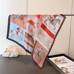 Vue détaillée d'un foulard en soie avec imprimés équestres et bordures marron foncé