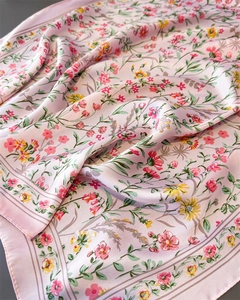 Vue détaillée d'un foulard en satin rose à motif floral et texture soyeuse
