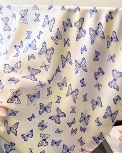Detailed view of lightweight semi-transparent silk scarf with dark blue butterfly prints