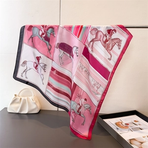 Détail d'un foulard en soie avec imprimé équestre, motifs de chevaux et drapé élégant