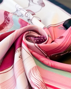 Détail macro d'un foulard en soie avec imprimé équestre montrant une texture douce et lisse