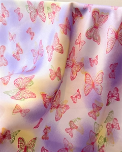 Detailed view of colorful butterfly print fabric with soft gradients and silk-like texture