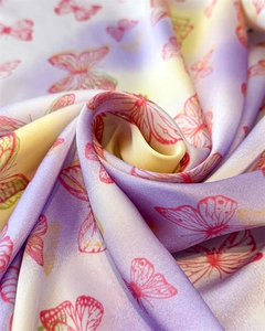 Detail of silk scarf showing vibrant butterfly prints and smooth purple gradient texture