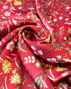 Gros plan sur foulard en satin rouge aux motifs floraux et texture soyeuse élégante