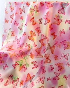 Detailed view of butterfly print on silky fabric with soft pink gradient finish