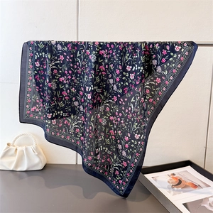 Détail de la texture du foulard en soie florale montrant le tissu léger et l'imprimé