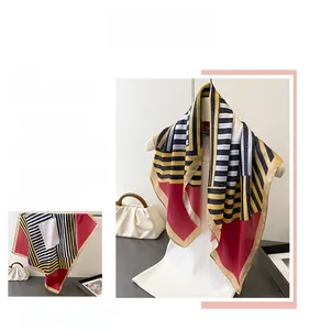 Detail view of geometric silk-like scarf with navy stripes and burgundy color blocks