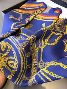 Détail du foulard en soie montrant l'imprimé chaîne vintage et le fini satiné