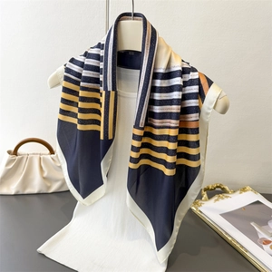Close-up of geometric striped silk scarf on mannequin showing fabric texture and edge detail