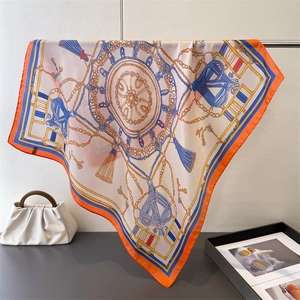 Détail du foulard effet soie avec motifs de chaînes dorées nautiques et mors de cheval