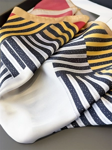 Close-up of geometric pattern silk scarf with striped details and soft fabric texture