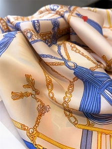 Gros plan d'un foulard en soie avec des motifs de chaînes et une texture satinée lisse