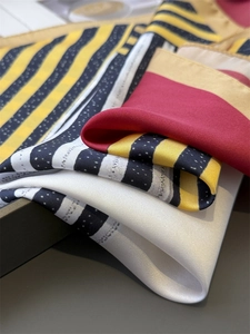 Detail of silk-like square scarf featuring geometric stripe and polka dot patterns
