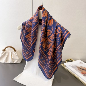Eleganter Seidenschal in Marineblau und Orange mit Blumenmuster am Kleiderbügel
