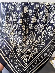 Detailansicht eines dunkelblauen Seidentuchs mit floralen Mustern im Volkskunst-Stil