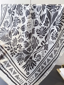 Detailansicht eines floralen Satin-Halstuchs mit schwarz-weißem Vintage-Muster