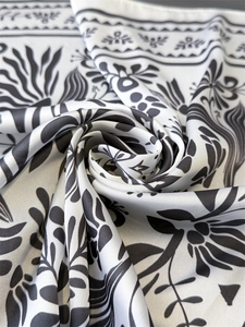 Nahaufnahme eines schwarz-weißen Seidenschals mit Blumenmuster und elegantem Satinglanz